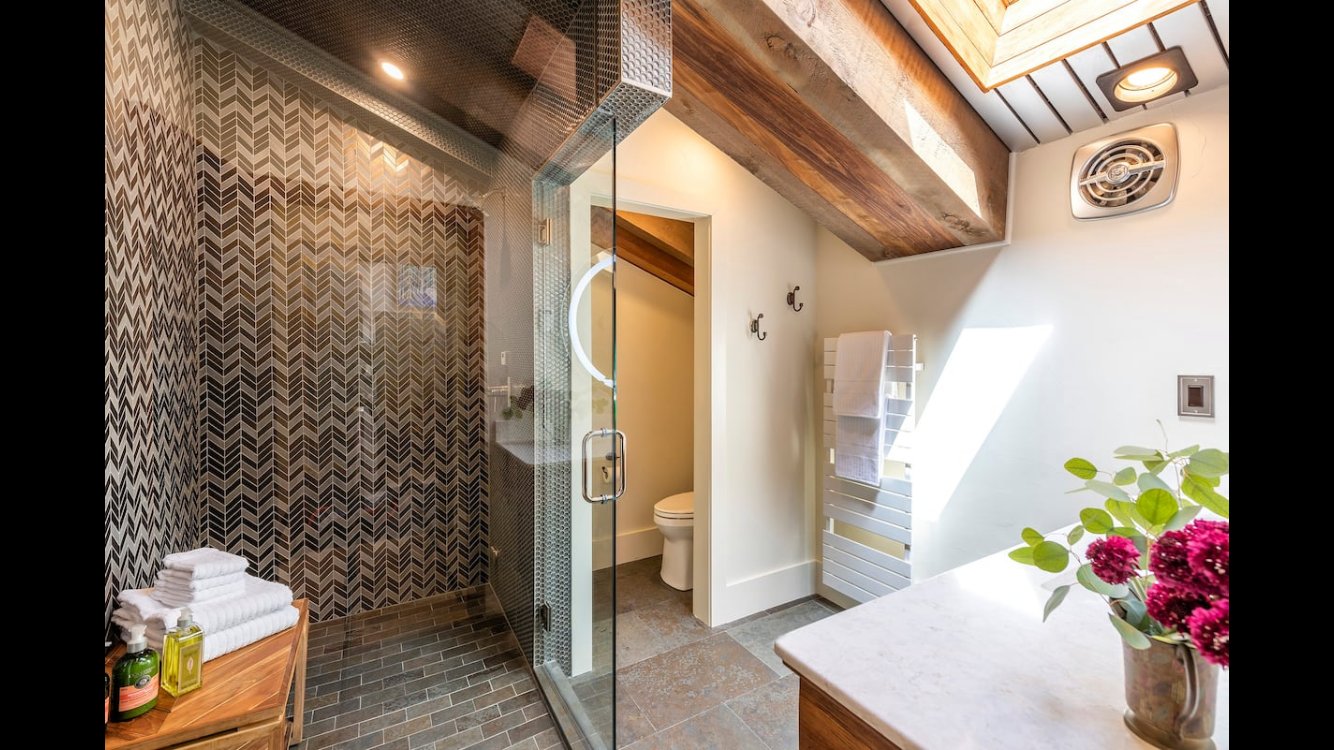 Custom herringbone shower with wood beam ceiling