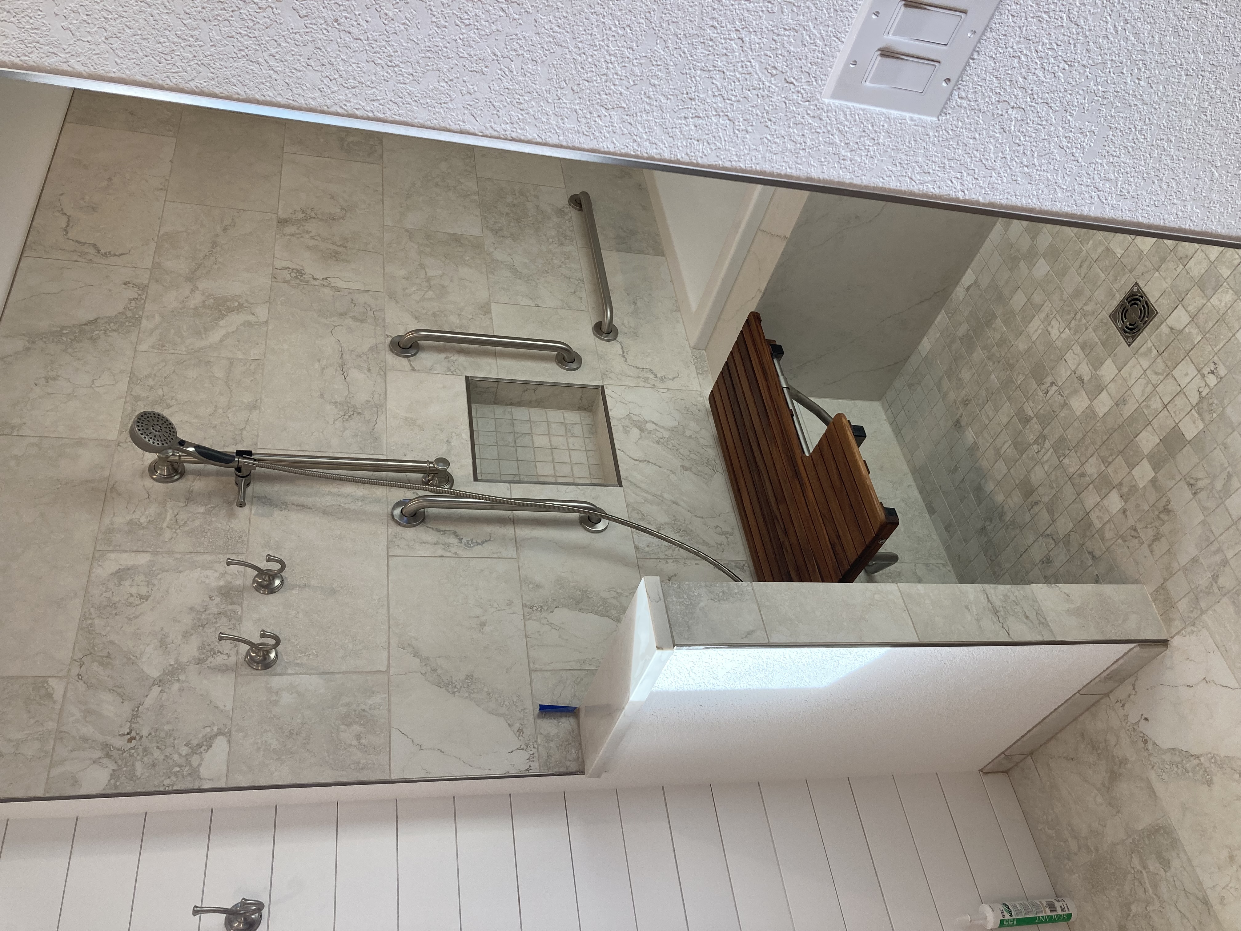 Marble accessibility shower with teak seat